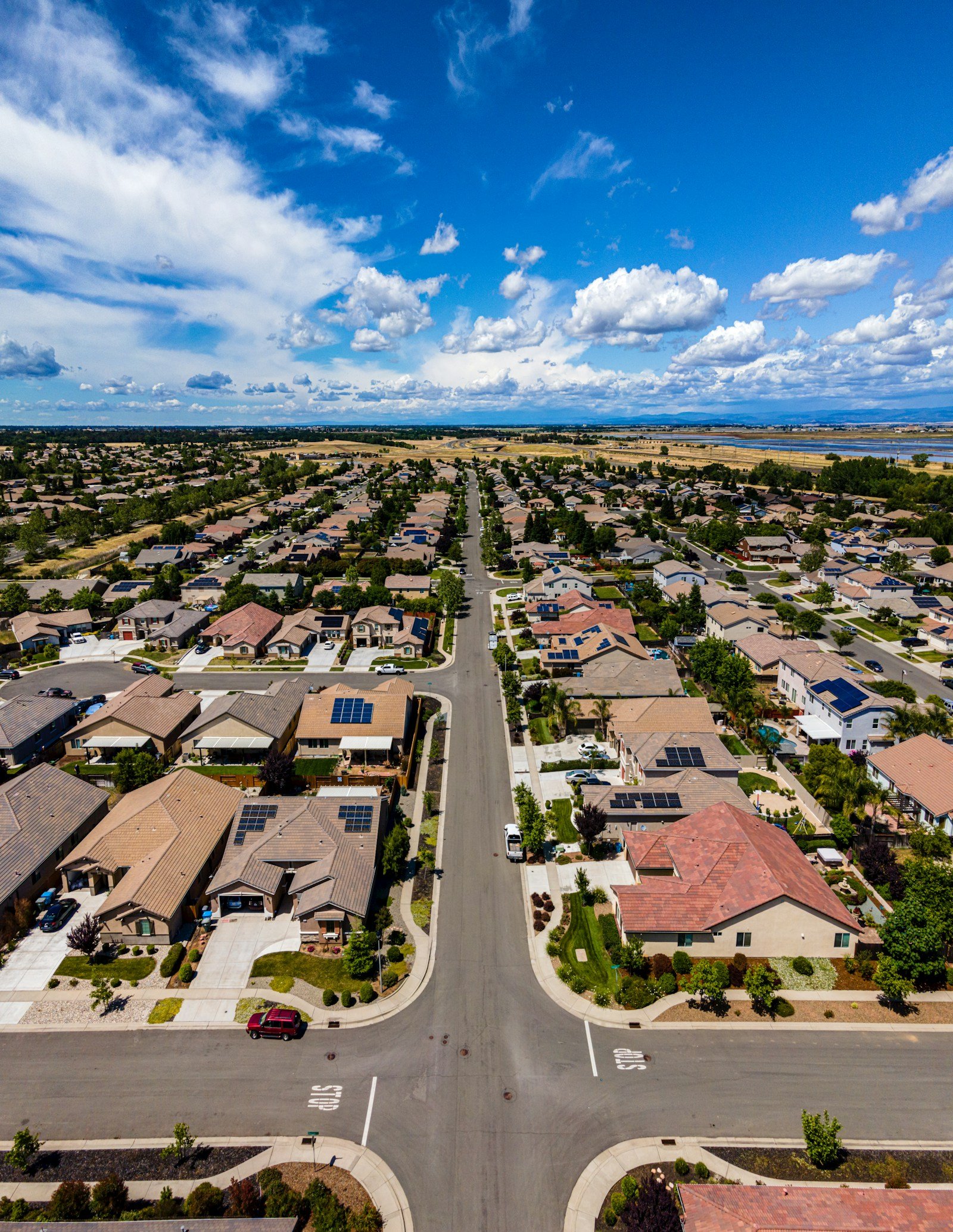 Aerial view of a newly built suburban neighbourhood with tile roofs and curved streets