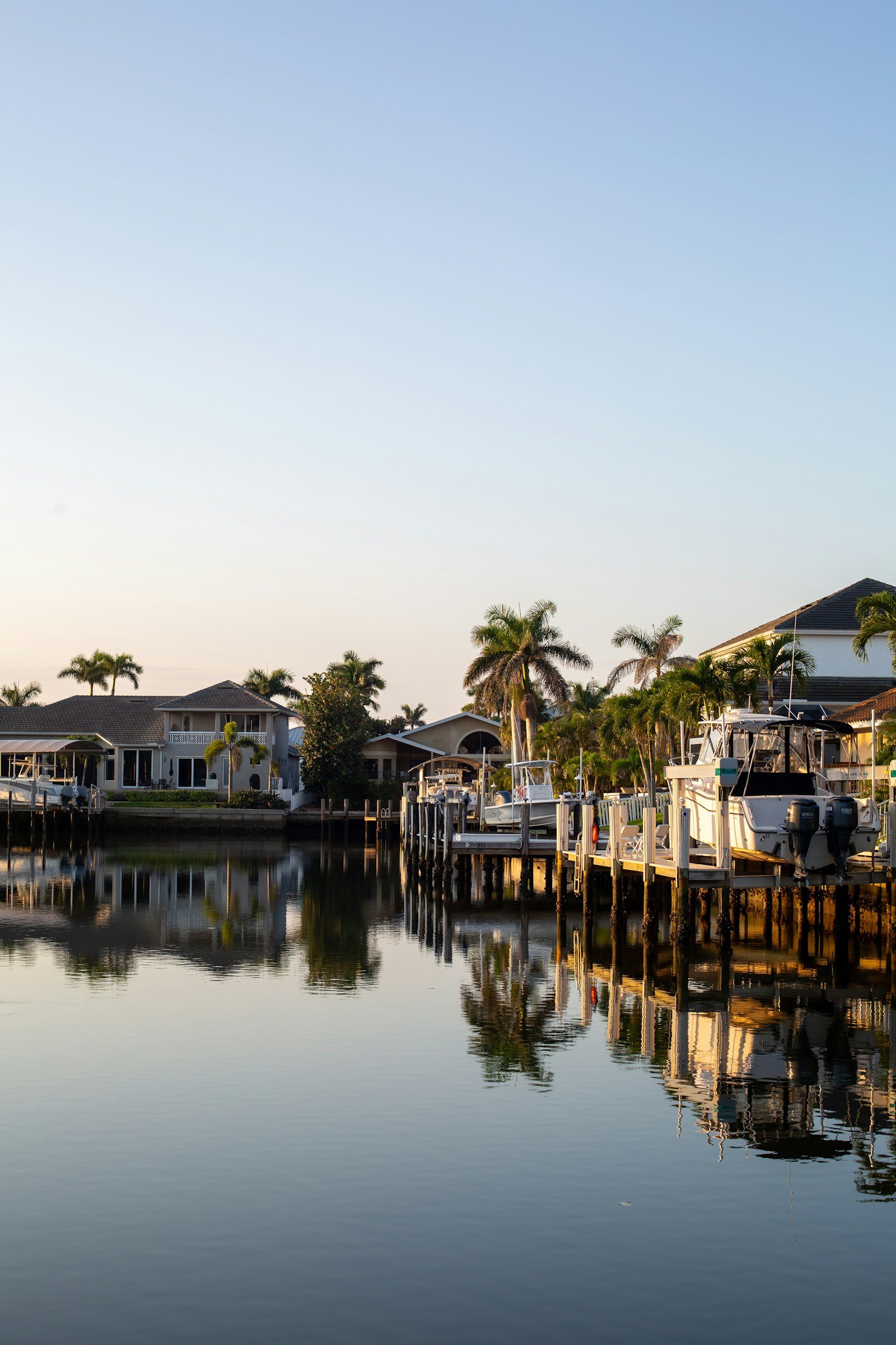 Waterfront homes with private docks and palms along a calm channel